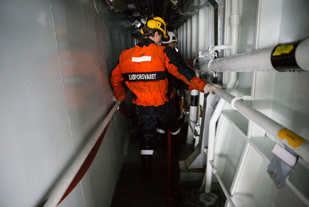 PÅ JOBB: Personell på KV Svalbard om bord på KV Andenes under en havariøvelse i 2015.