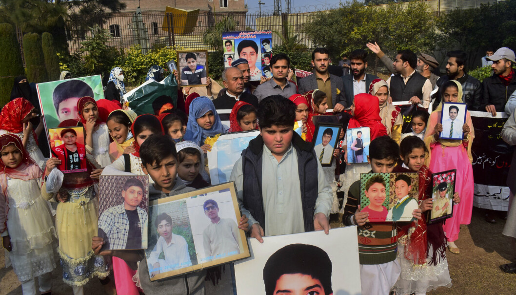 MINNESEREMONI: Pakistanske familier med bilder av dem de mistet da TPP angrep en skole i Peshawar i 2014. Bildet ble tatt under en minneseremoni 14. desember i fjor.