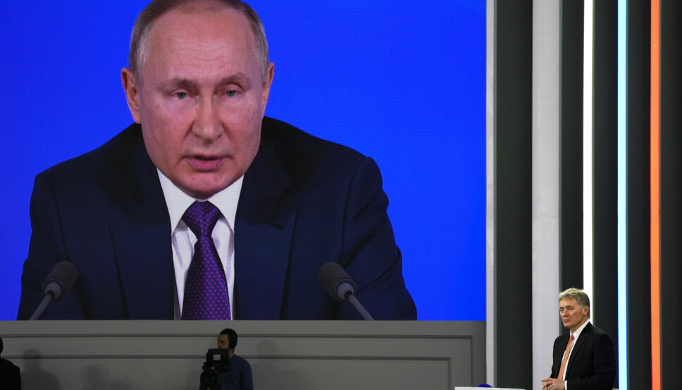 Kremls talsmann Dmitrij Peskov (til høyre) lytter til sjefen, Russlands president Vladimir Putin, på en pressekonferanse i Moskva i desember.