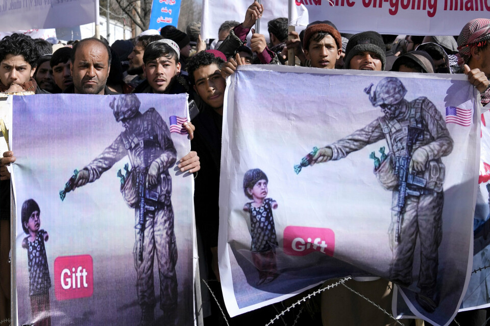 Protesters hold banners, during a protest condemning President Joe Biden's decision on frozen Afghan assets in Kabul, Afghanistan, Tuesday, Feb. 15, 2022. Biden signed an executive order, Friday, Feb. 11, 2022, to create a pathway to split $7 billion dollars of Afghan assets frozen in the U.S. to fund humanitarian relief in Afghanistan and to create a trust fund to compensate Sept. 11 victims. (AP Photo/Hussein Malla)