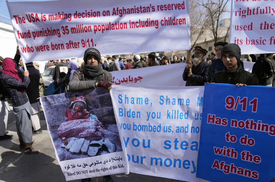 Afghan protesters hold banners, during a protest condemning U.S.President Joe Biden's decision, in Kabul, Afghanistan, Tuesday, Feb. 15, 2022. President Biden signed an executive order, Friday, Feb. 11, to create a pathway to split $7 billion in Afghan assets frozen in the U.S. to fund humanitarian relief in Afghanistan and to create a trust fund to compensate Sept. 11 victims. (AP Photo/Hussein Malla)