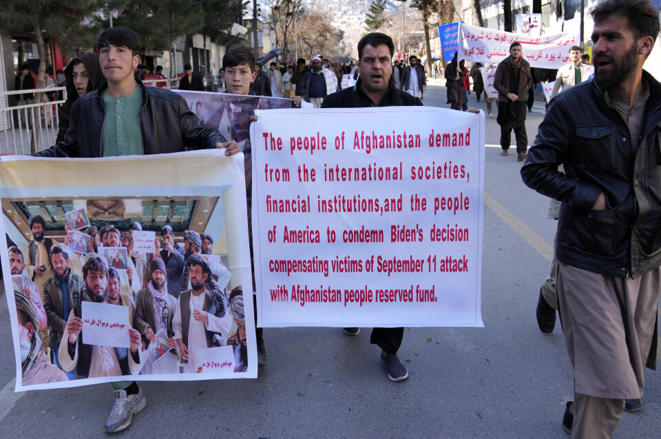 Afghan protesters hold banners, as they march during a protest condemning President Joe Biden's decision, in Kabul, Afghanistan, Tuesday, Feb. 15, 2022. President Biden signed an executive order, Friday, Feb. 11, 2022, to create a pathway to split $7 billion in Afghan assets frozen in the U.S. to fund humanitarian relief in Afghanistan and to create a trust fund to compensate Sept. 11 victims. (AP Photo/Hussein Malla)