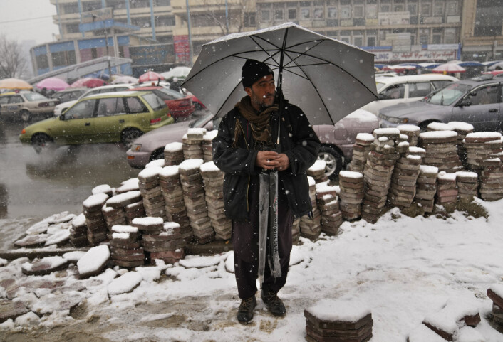 ØKONOMI: En afghansk paraplyselger forsøker å få solgt varene sine i snøværet i Kabul. ØKONOMI: En afghansk paraplyselger forsøker å få solgt varene sine i snøværet i Kabul.