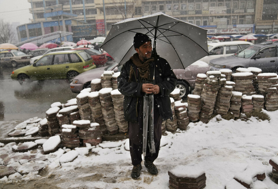 ØKONOMI: En afghansk paraplyselger forsøker å få solgt varene sine i snøværet i Kabul.