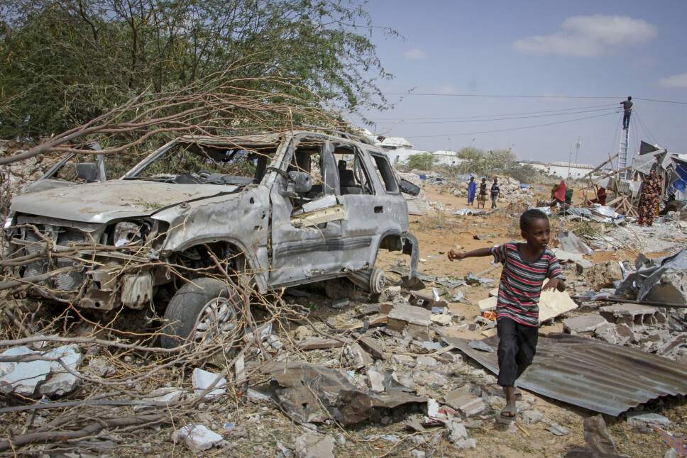 DØDELIG ANGREP: En ung gutt løper forbi vraket av et kjøretøy som ble ødelagt i et angrep på politi og kontrollposter i utkanten av hovedstaden Mogadishu, Somalia onsdag 16. februar 2022.