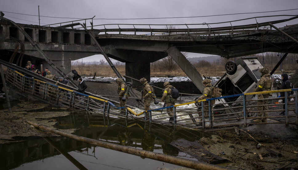 ØDELAGT: Ukrainske soldater krysser en ødelagt bro, i utkanten av Kyiv, onsdag 2. mars.