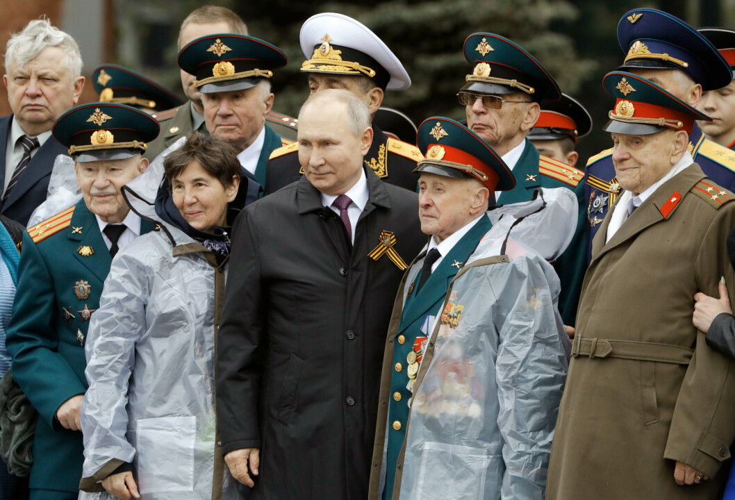 BESETTELSE: Russlands president Vladimir Putin poserer på et bilde sammen med veteraner fra andre verdenskrig under en kransenedleggelse ved den ukjente soldats grav på seiersdagen for Den store fedrelandskrigen, i Moskva 9. mai 2021.