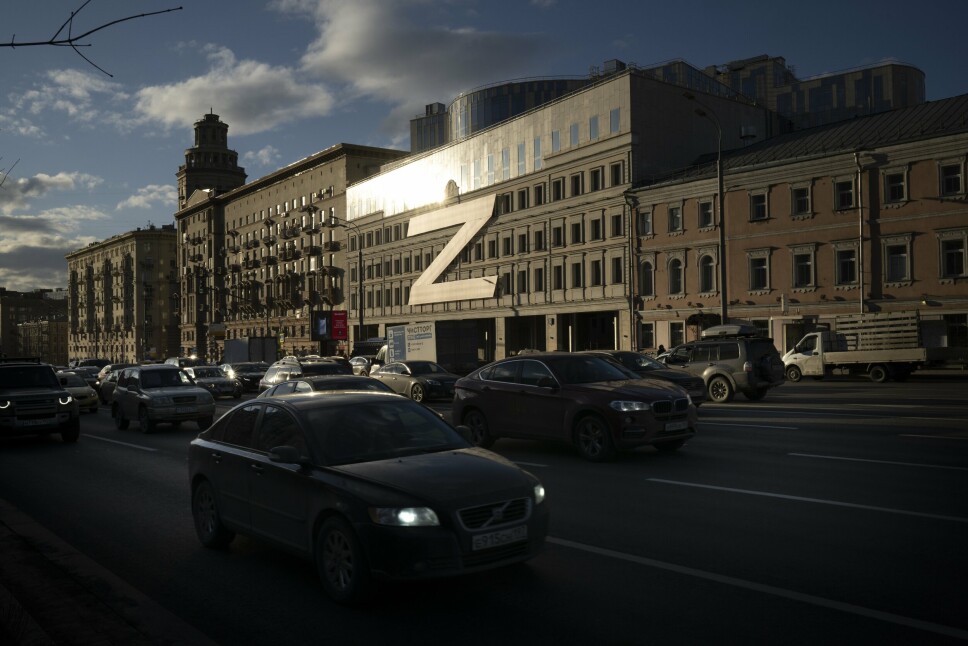 SYMBOL: Biler kjører ned en gate med en stor bokstav Z, som har blitt et symbol på det russiske militæret, og en hashtag som leser 'Vi forlater ikke våre egne' på en bygning under solnedgang i Moskva, Russland, onsdag 30. mars 2022.
