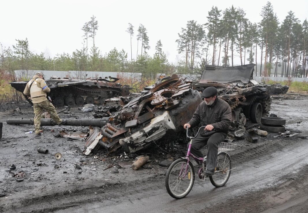 ANGREP: Drapene i Dmytrivka ser ut til å være resultatet av et ukrainsk overfallsangrep på en russisk militærkolonne rundt 30. mars. På bildet sykler en mann forbi en ødelagt russisk stridsvogn, tatt den 2. april 2022. ANGREP: Drapene i Dmytrivka ser ut til å være resultatet av et ukrainsk overfallsangrep på en russisk militærkolonne rundt 30. mars. På bildet sykler en mann forbi en ødelagt russisk stridsvogn, tatt den 2. april 2022.