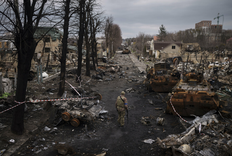 RUINER -En ukrainsk tjenestemann går blant ødelagte russiske stridsvogner i Butsja, i utkanten av Kiev. Bildet er tatt 6.april 2022