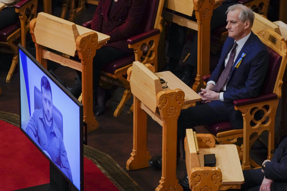 REISER IKKE: Statsminister Jonas Gahr Støre lytter til Ukrainas president Volodymyr Zelenskyj tale til Stortinget 30. mars.