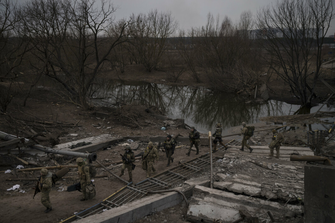SOLDATER: Utenlandske og ukrainske soldater krysser en improvisert sti under en ødelagt bro i Irpin, utkanten av Kiev, Ukraina.