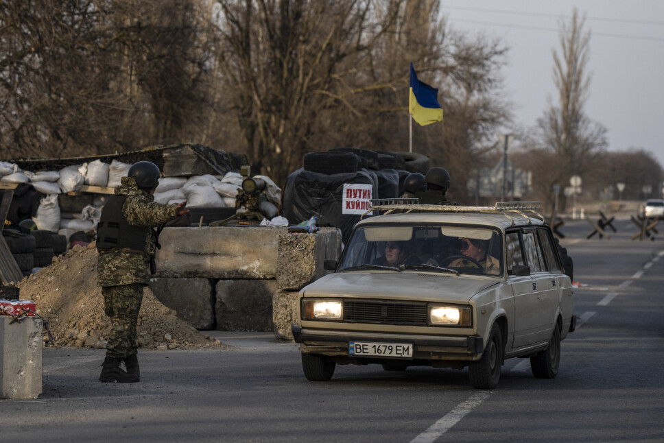 SOLDAT: En Ukrainsk soldat tillater en bil å passere en kontrollpost ved Mykolaiv.