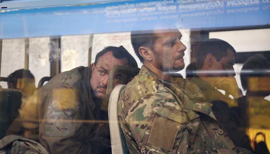 EVAKUERT: Ukrainske tjenestemenn sitter i en buss etter at de ble evakuert fra det beleirede Mariupols Azovstal stålverk, nær et varetektsfengsel i Olyonivka, på territorium under regjeringen til Folkerepublikken Donetsk, øst i Ukraina, tirsdag 17. mai.