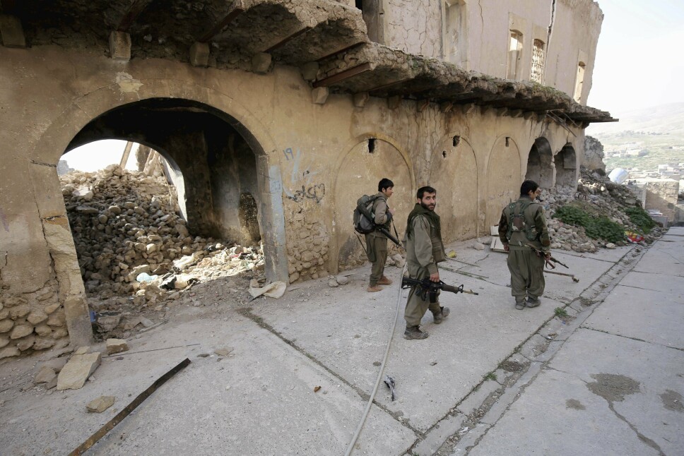 ØDELEGGELSE: Bildet fra 2015 viser tre soldater fra PKK som går i en ødelagt gate i Irak.