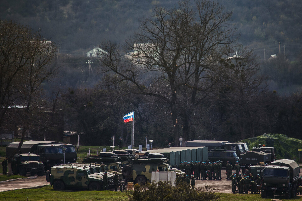 2014: Et russisk flagg er heist i en tidligere ukrainsk militærleir utenfor Simferopol, Krim.