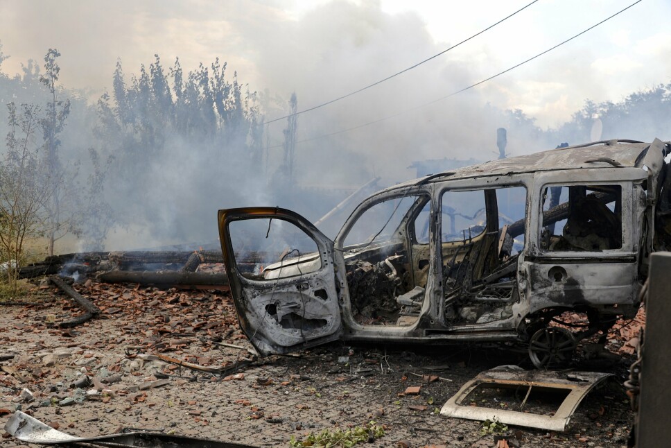 ØDELEGGELSER: Røyk stiger opp fra de sløyde restene av et kjøretøy og et hus, etter et angrep i Donetsk i østlige Ukraina. Bildet ble tatt fredag 17. juni 2022.
