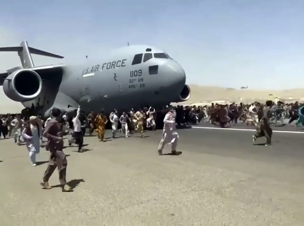 KABUL: Folk som ønsker å forlate Afghanistan løper ved siden av et amerikansk militærfly på flyplassen i Kabul 16. august 2021. KABUL: Folk som ønsker å forlate Afghanistan løper ved siden av et amerikansk militærfly på flyplassen i Kabul 16. august 2021.