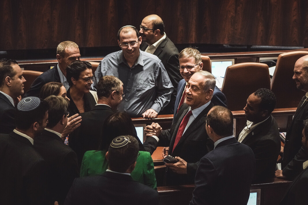 COME-BACK: I ett år har Benjamin Netanyanhu kritisert den israelske regjeringen nord og ned. Nå øyner den den tidligere statsministeren muligheten til å komme tilbake i statsministerposten. Her gratuleres Netanyanhu av sine partikolleger etter en foreløpig avstemning om et lovforslag om å oppløse parlamentet, i Knesset, onsdag 22. juni i år. I en foreløpig avstemning stemte Israelske lovgivere for å oppløse parlamentet, og satte hjulene i gang for å sende Israel til sitt femte nasjonale valg på litt over tre år.