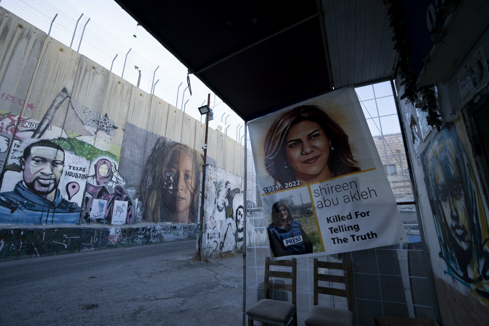 MINNE: Shireen Abu Akleh var en velkjent og respektert reporter som hadde dekket Palestina-konflikten i flere tiår. Hun var et kjent ansikt på TV, og drapet vakte protester i medier over hele verden, og også fra amerikanske myndigheter. Her blir hun minnet på en plakat ved muren i Betlehem på den okkuperte Vestbredden.