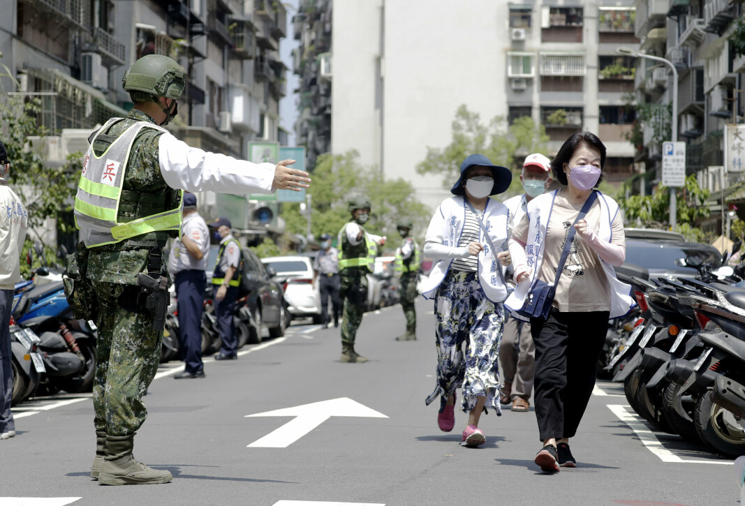 MILITÆRØVELSE: Folk blir guidet av Taiwans soldater til et tilfluktsrom under Wanan-luftangrepsøvelsen i Taipei, Taiwan, mandag 25. juli 2022.