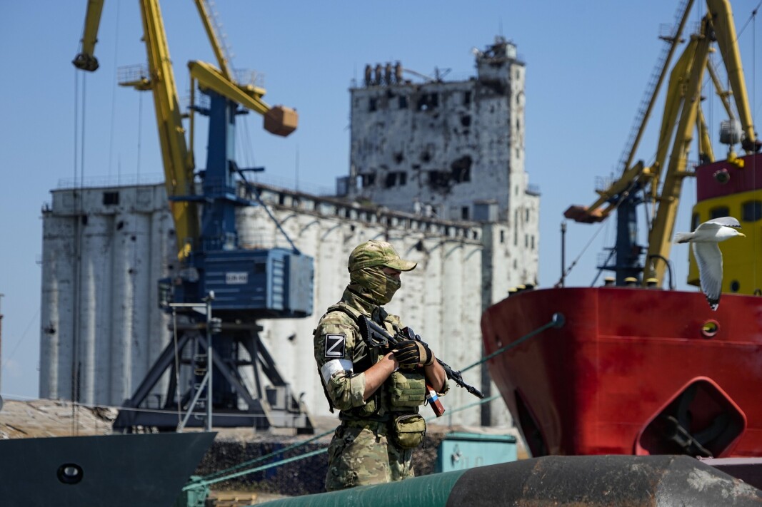 KORNEKSPORT: En russisk soldat står på vakt ved havnen i Mariupol. Bak soldaten ligger et kornlager som Ukraina anklager Russland for å ha stjålet. Bildet er fra 12. juni 2022. KORNEKSPORT: En russisk soldat står på vakt ved havnen i Mariupol. Bak soldaten ligger et kornlager som Ukraina anklager Russland for å ha stjålet. Bildet er fra 12. juni 2022.
