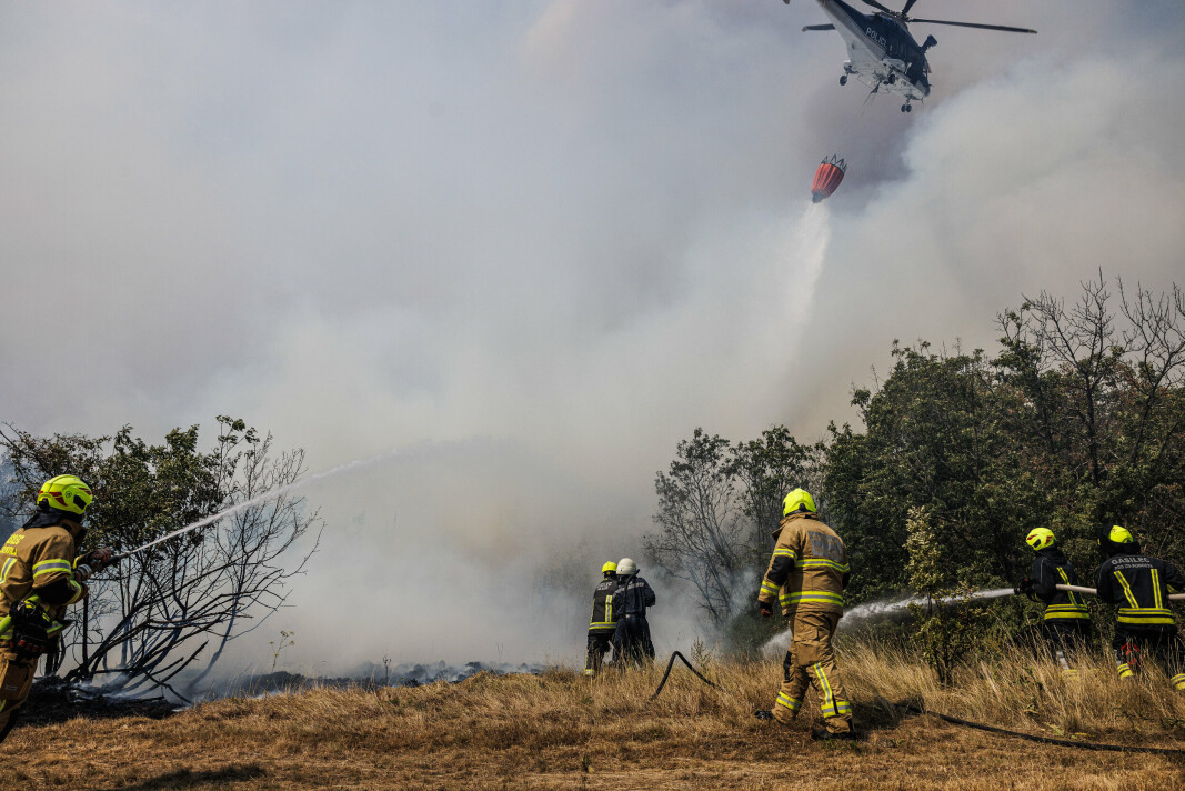 SKOGBRANN: Brannmannskaper og et helikopter kjemper mot flammene nær landsbyen Temnica i Karst-regionen i Slovenia. Bildet er datert 22. juli 2022.