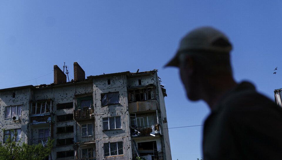 DONBAS: En mann spaserer forbi en sterkt skadd boligblokk i Slavjansk, en av de siste byene ukrainerne fortsatt holder i Donbas.
