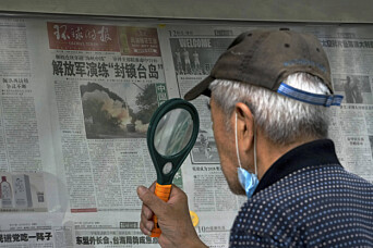 ØVELSE: En mann i Beijing bruker forstørrelsesglass til å lese en avis med nyheter om de omfattende militærøvelsene Kina satte i gang etter Nancy Pelosis besøk på Taiwan. ØVELSE: En mann i Beijing bruker forstørrelsesglass til å lese en avis med nyheter om de omfattende militærøvelsene Kina satte i gang etter Nancy Pelosis besøk på Taiwan.