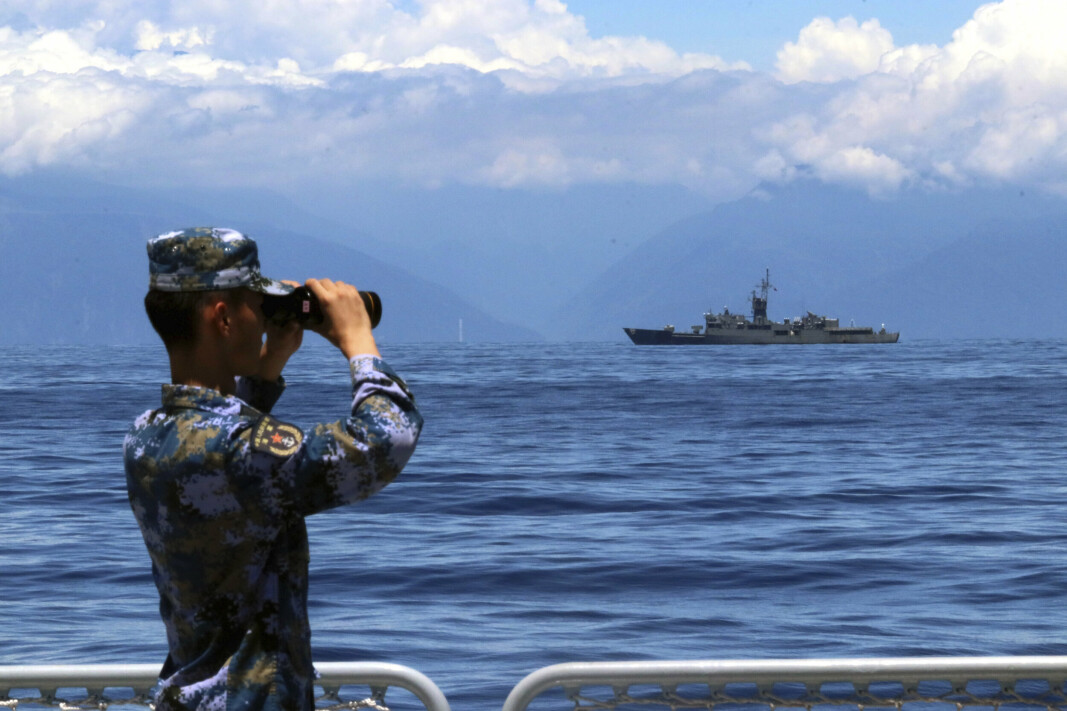 MILITÆRØVELSE: En soldat fra Folkets frigjøringshær ser på en taiwansk fregatt under Kinas militærøvelse, fredag 5. august 2022.