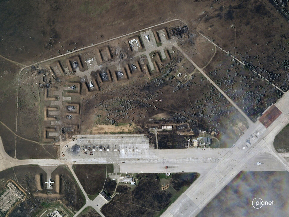 ØDELAGT: Et satellittbilde av flybasen på Krim etter tirsdagens eksplosjoner. Bildet viser flere ødelagte fly, samt flere kratre.
