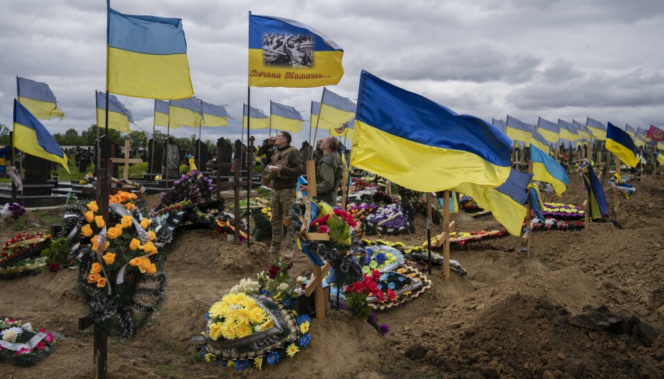 MINNES DE FALNE: To ukrainske soldater tømmer hvert sitt lille glass for å hedre to falne kamerater på en kirkegård i Kharkiv 22. mai 2022.
