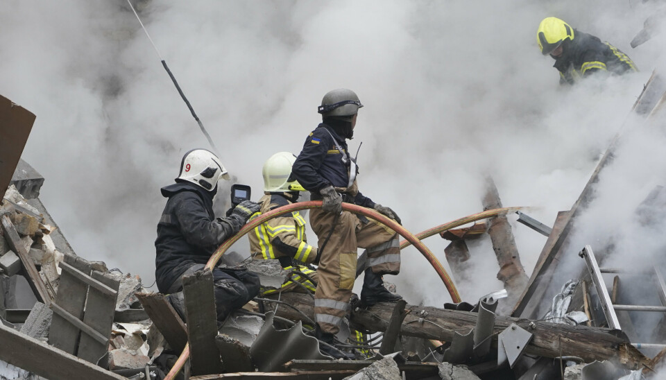 BRANN: Brannbetjenter jobber med å slukke flammene etter et angrep i Kharkiv 6. september.