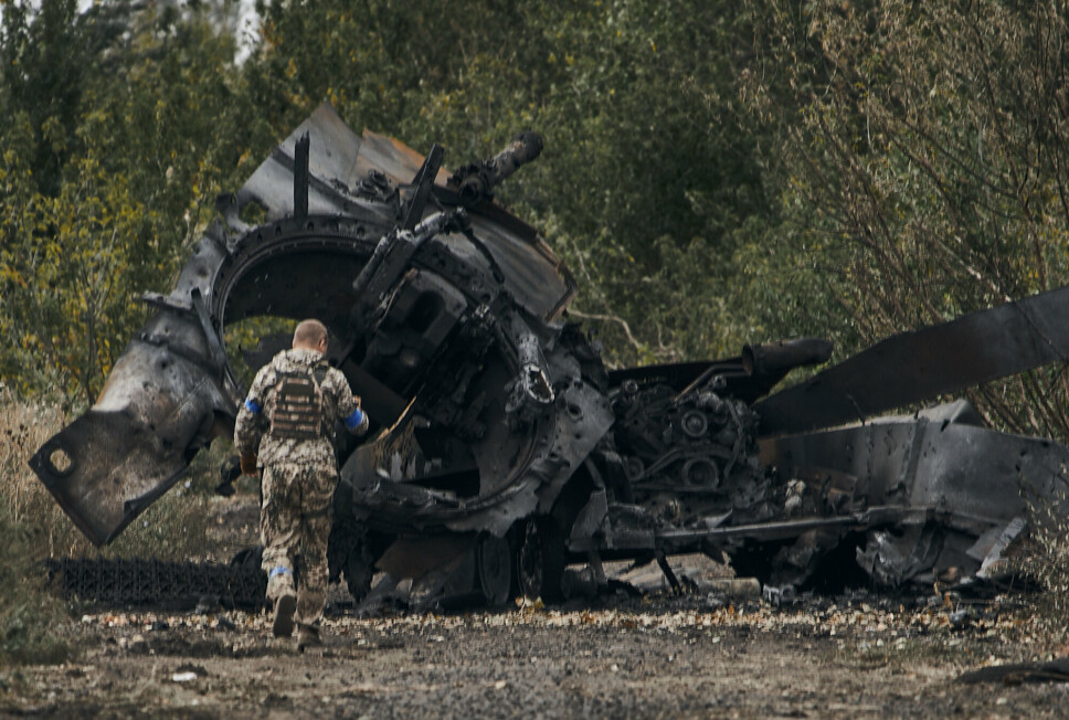 TAR TILBAKE OMRÅDER: En ukrainsk soldat går forbi en russisk tanks som ble ødelagt under kampene på vei til Balakleva i Kharkiv-regionen søndag.