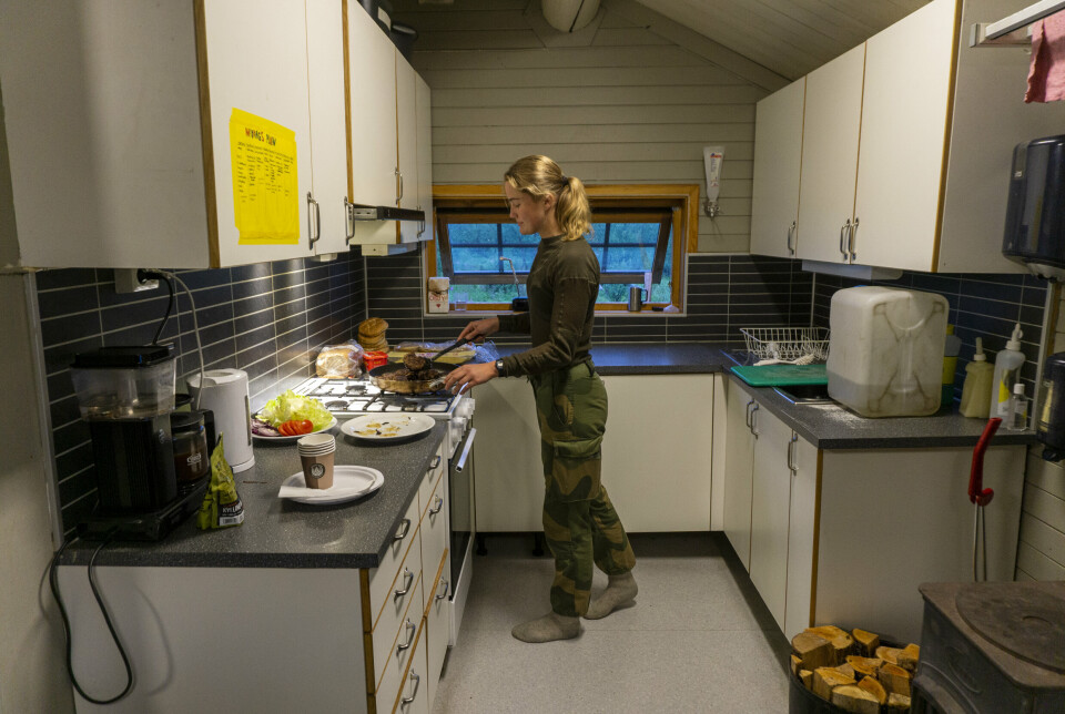 ALLE GJER ALT: Sofie Mellgren er dagens kokk og steikjer hamburgarar. Alle arbeidsoppgåver på grensevakthytta er delte mellom dei fire medlemmane i patruljen.