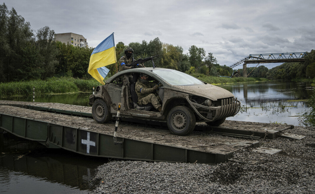 IZIUM: Ukrainske soldater med et ukrainsk flagg på en provisorisk bru over elva Donets ved gjenerobrede Izium.