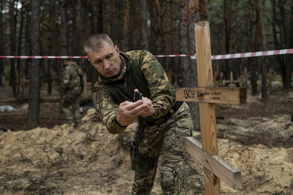 FILMER: Oleg Kotenko, som leder Ukrainas kommisjon for savnede personer, filmer en grav der en ukrainsk soldat ligger begravet.