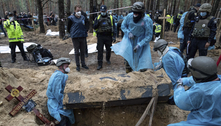 PREGET: Ukrainsk personell henter opp en kiste med levninger ifra massegravstedet i Izium. Ukrainske myndigheter sier noen av likene bærer preg av å ha blitt utsatt for tortur.