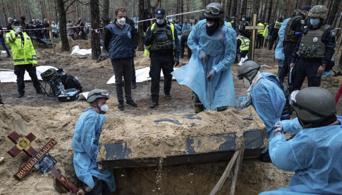 PREGET: Ukrainsk personell henter opp en kiste med levninger ifra massegravstedet i Izium. Ukrainske myndigheter sier noen av likene bærer preg av å ha blitt utsatt for tortur. PREGET: Ukrainsk personell henter opp en kiste med levninger ifra massegravstedet i Izium. Ukrainske myndigheter sier noen av likene bærer preg av å ha blitt utsatt for tortur.