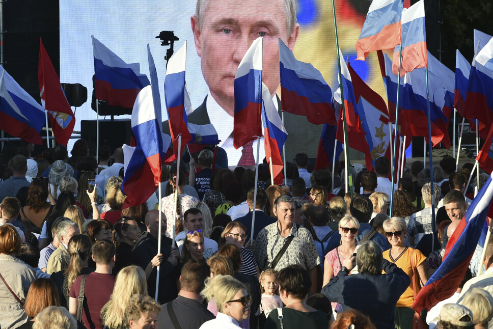 FEIRING: Vladimir Putins bilde på en storskjerm bak russiske flagg under den storstilte feiringen av at Russland har annektert nye regioner fredag. Dagen etter gikk russerne på et nytt nederlag i Ukraina.