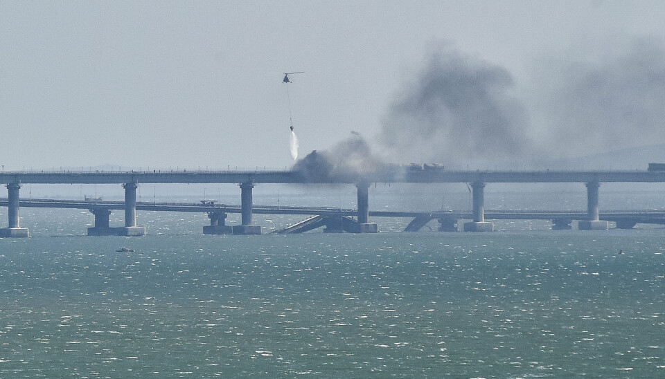 SLUKKER: Et helikopter i gang med slukking av brannen på Krim-brua.