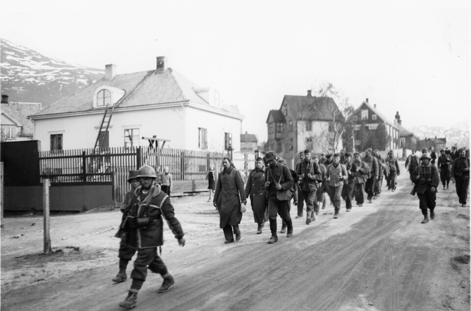 KRIGSFANGER: Tyske krigsfanger voktet av polske soldater føres gjennom Narvik etter gjenerobringen av byen 28. mai 1940.