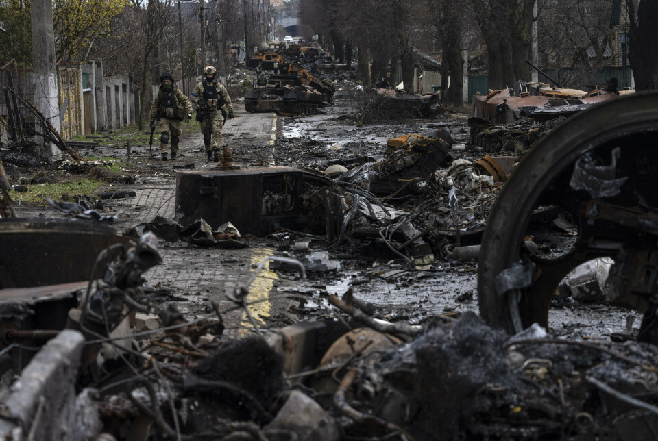 RASERING: Soldater går blant ødelagte russiske stridsvogner i Butsja utenfor Kyiv i april.