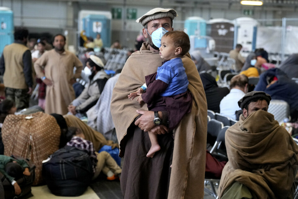 FLYKAOS: Særlig menn fra afghanske spesialstyrker som rømte til Iran etter kaoset under fjorårets amerikanske tilbaketrekking blir nå rekruttert av Russland. Her venter folk på avgang ved en hangar på Ramstein U.S. Air Base i Tyskland i fjor.