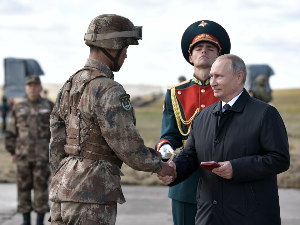 SAMARBEID: Russlands president Vladimir Putin håndhilser på en kinesisk soldat under en felles militærøvelse i det østlige Sibir i 2018.