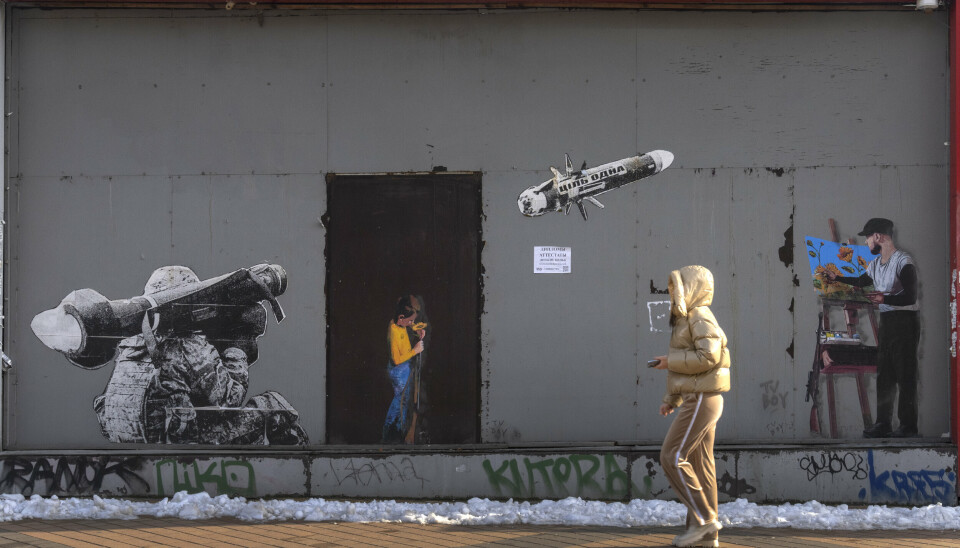 I BEVISSTHETEN: En kvinne i Kyiv i Ukraina passerer et gatekunstverk som viser en soldat avfyre et missil. Bildet er datert 1. februar.