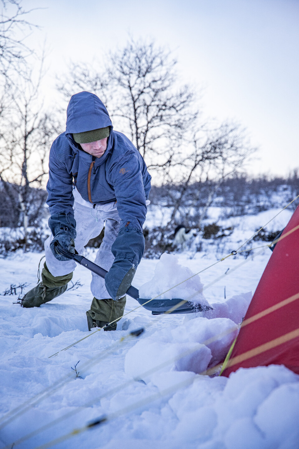 SIKRES MED SNØ: Stormmattene brettes ut og snø skuffes på. Teltet blir ekstra stabilt og komforten deretter. Helsport har mange gode vintertelt, samt Hilleberg, men her må storm-matter spesifiseres ved kjøp og sys på. En løsning om man har et vintertelt uten storm-matter er å skuffe snø rundt teltet, tett opp mot teltduken for å oppnå tilsvarende effekt. Hovedpoenget er å tette muligheten for vind og snø å komme inn i teltet fra under teltduken.