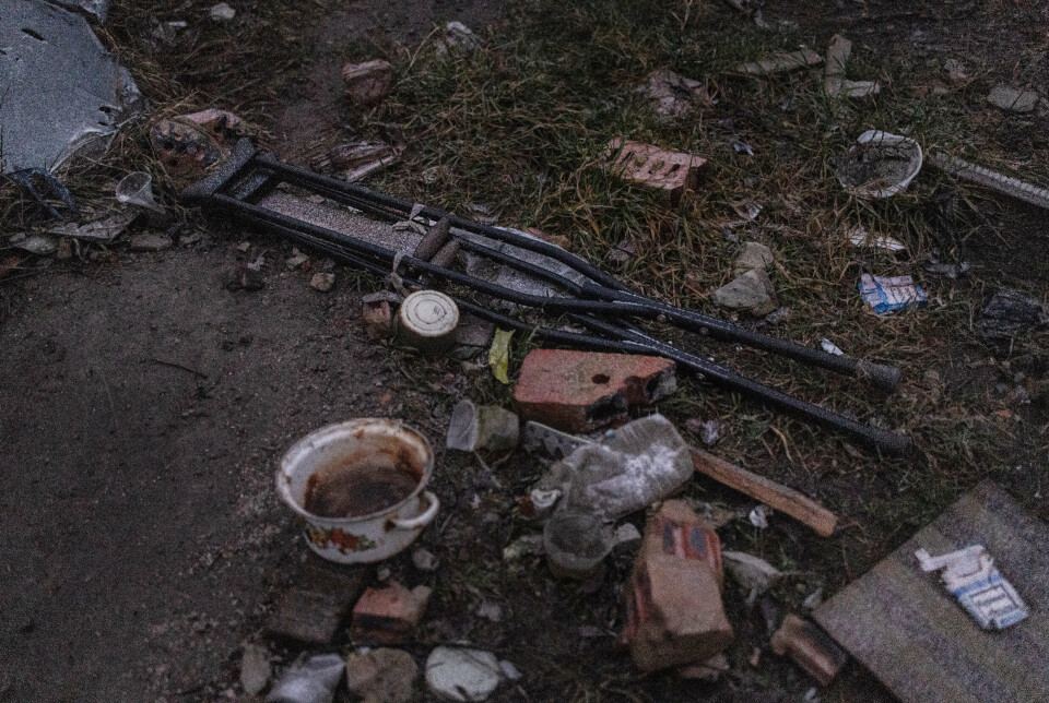 FORLATT: Et par krykker og en kjele ligger igjen i landsbyen Dolyna i Øst-Ukraina. Alle menneskene har flyktet, og det er bare løsbikkjer igjen i ruinene.