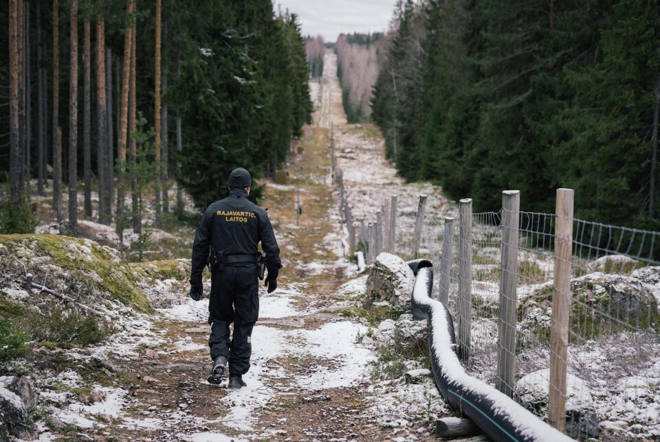 En grensevakt går langs gjerder som markerer grensen mellom Finland og Russland, Pelkola i Imatra, 18. november, 2022.