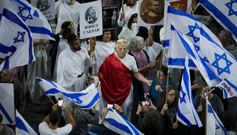 DEMONSTRANTER: Midt i en folkemengde har en av demonstrantene tatt på seg en maske der Isralels statsminister, Benjamin Netanyahu er kledd som Cæsar. Folkmassen demonstrerer mot Betanyahus reformering av rettsvesenet. Bildet er tatt 4. mars 2023 i Tel Aviv.